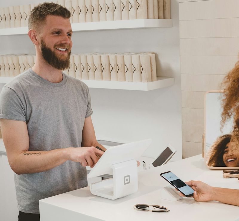 A shop owner serving a customer at the counter