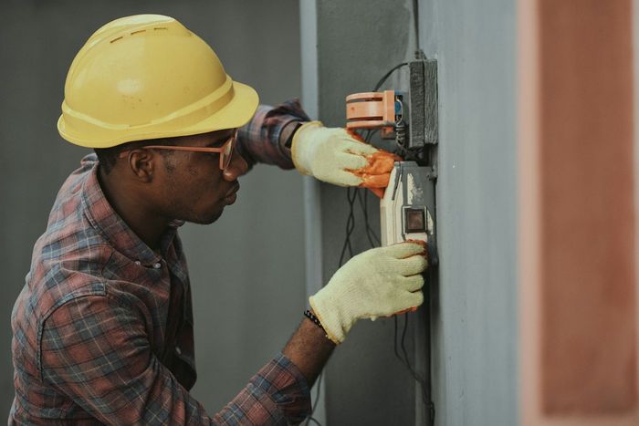 An electrician working on a wall panel